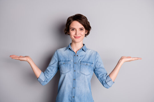 Photo of attractive lady hold open arms hands empty space showing nice offer two variants pick select best one wear casual denim shirt isolated grey color background