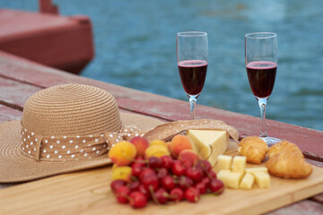 Two glasses of red wine, served outdoor with fruits and beautiful blue ocean view.