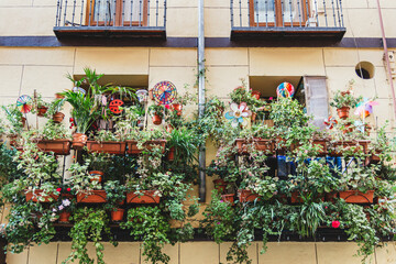Fototapeta na wymiar Nice balcony with many plants and decorations in the historic center of the city of Madrid, Spain.