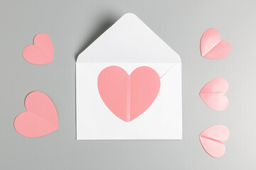  pink hearts and white envelope on a gray background. valentine's day and love concept. top view, minimalism