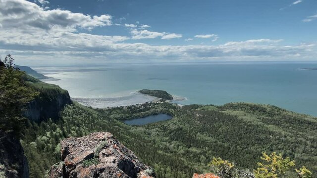 DSLR Camera In Tripod Stands On The Edge Of Cliff. Stunning Landscape of Bic National Park With Serene Coast, Islands, And Green Forest In Rimouski, Quebec, Canada. - push in shot