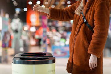 Woman throws object in trash can. Template with empty space