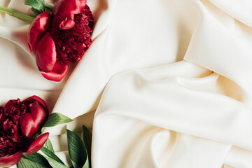 top view of bouquet of red peonies on white cloth