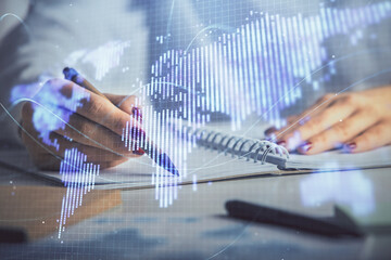 International business hologram over hands taking notes background. Concept of success. Multi...