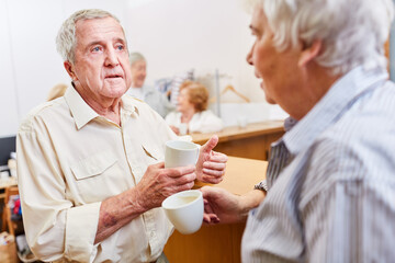 Two seniors have a cup of coffee together