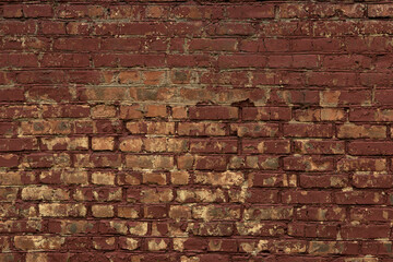 Red curved old brick wall with uneven masonry, stained with paint, painted burgundy and cracked