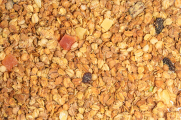 Background from grains of cereals with dry fruits. Muesli texture.