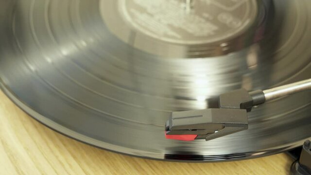Black vinyl Record Player spinning. Playing album on a vintage turntable. Retro old school music playing device. Pro Res 4K