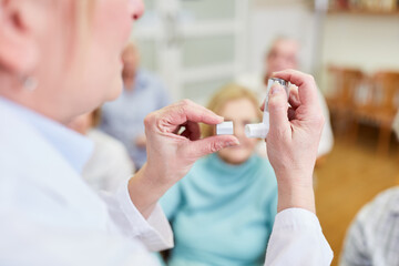 Doctor explains to senior citizens a metered dose inhaler