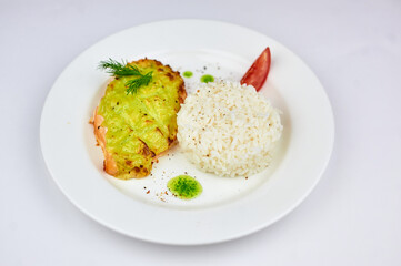 A white plate topped with rice meat and vegetables