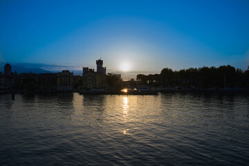 Sunrise over Sirmione, Lake Garda Italy. Blue sky, trail from the sun on the water. Aerial view