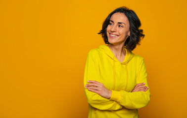 Happy sight. Half-length photo of a toothy smiling girl with her hands crossed on chest, looking...