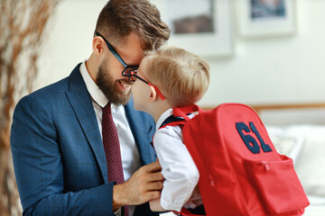 Happy father supporting son before going to school.