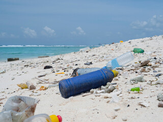 CLOSE UP: Empty plastic bottles are flooded onto the tropical white sand beach.