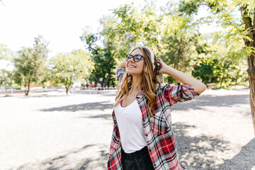 Naklejka premium Magnificent girl in casual clothes laughing in spring day. Pleased blonde woman enjoying summer weekend.