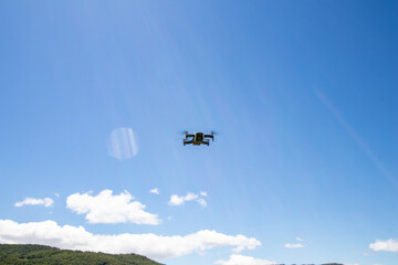 Fototapeta na wymiar Drone in flight hovering in a flowery field in the spring in the mountains. Aerial shots and selfies with the drone. Control and agriculture with drone.