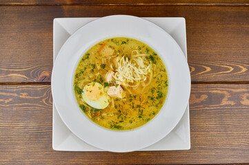 soup noodles with egg and herbs on a dark background