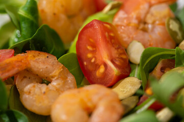 close up view of fresh green salad with pumpkin seeds, cherry tomatoes, shrimps and avocado