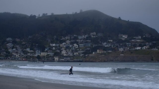 Surfer goes out into waves