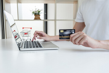 Young man people who hold credit cards and use laptops for online shopping and making payments Internet