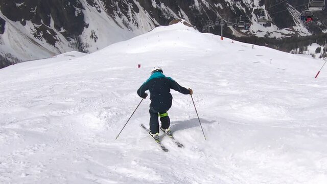 Skiing mogules fast and in control on a steep ski slope. Bumbs skiing with great ski technique.
