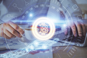 Crypto currency theme hologram with businessman working on computer on background. Concept of blockchain. Double exposure.