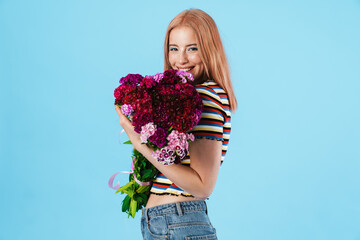 Image of cheerful beautiful pretty girl posing with flowers and smiling