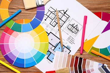 Color palettes with paint brush and building plan on wooden background