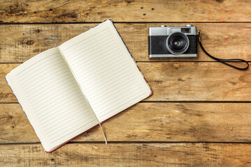 Old wooden background with notebook photo camera