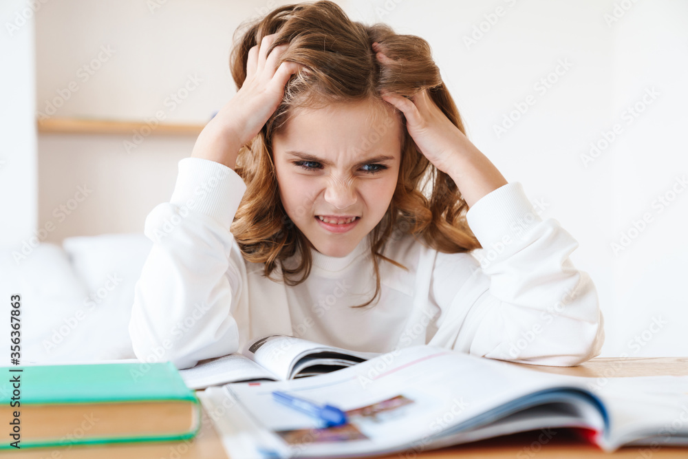 Sticker photo of displeased girl grabbing her head while doing homework