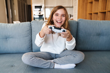 Photo of excited nice girl smiling and playing video game with joystick