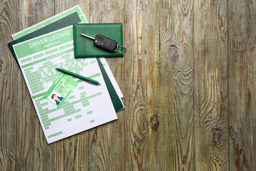 Driving license with application form, passport and car key on wooden background