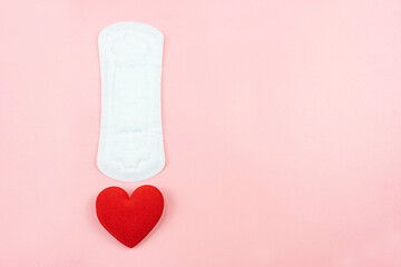 Top view white sanitary napkin and red heart isolated on pink  background with copy space. Woman hygiene, Concept of critical days, menstruation,health care