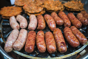 Frying sausages on a grill on a chinese market stall