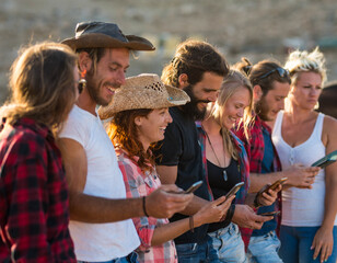 group of seven people using their phone together and enjoying - adults having fun and surfing in the net - social media and social network lifestyle and concept - happy and healthy people