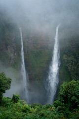 Fototapeta na wymiar Tall waterfall in the misty jungle