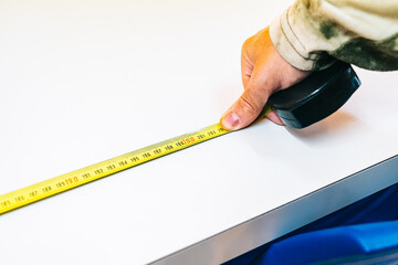 Measuring with a ruler the safe distance between school tables so that students maintain a safe distance of two meters.