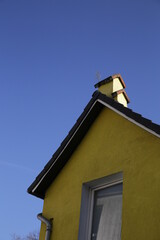 Gelber Giebel mit Satteldach  und Schornstein