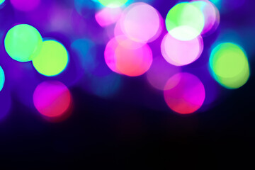 Colorful bokeh in the dark background, beautiful bright colors. party lights, christmas tree decorative lights, blinking, flickering lights.