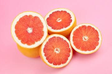 Pink grapefruit fruits on trendy pink background, top view