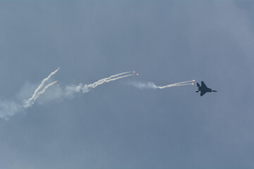 Military fighter jet dispensing flare counter measure.
