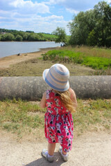 little girl in a hat looking at a lake in England 