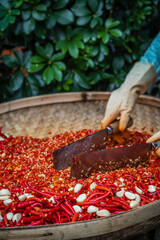 Chillies and garlic being chopped in a wicker bowl