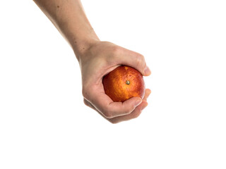 White man holds a blood orange in his hand