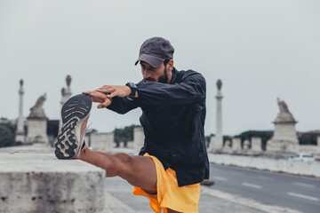 Uomo atletico esegue un esercizio di stretching delle gambe con concentrazione durante una sessione...