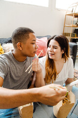 Interracial couple in love eating takeaway chinese food at home