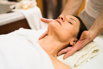Fototapeta na wymiar Caucasian woman at massage salon having head treatment by professional physio therapist masseur