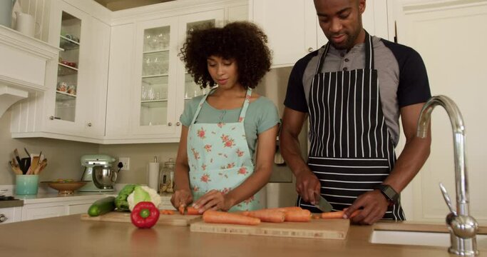  Happy mixed race couple cooking and dancing in their kitchen
