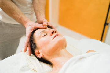Fototapeta na wymiar Caucasian woman at massage salon having head treatment by professional physio therapist masseur