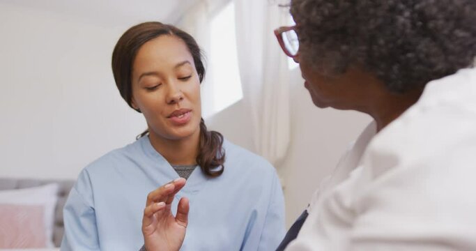 Mixed race woman being visited at home by a nurse. Social distancing and self isolation in quarantin